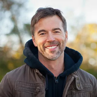 Portrait of a smiling man wearing a dark hoodie